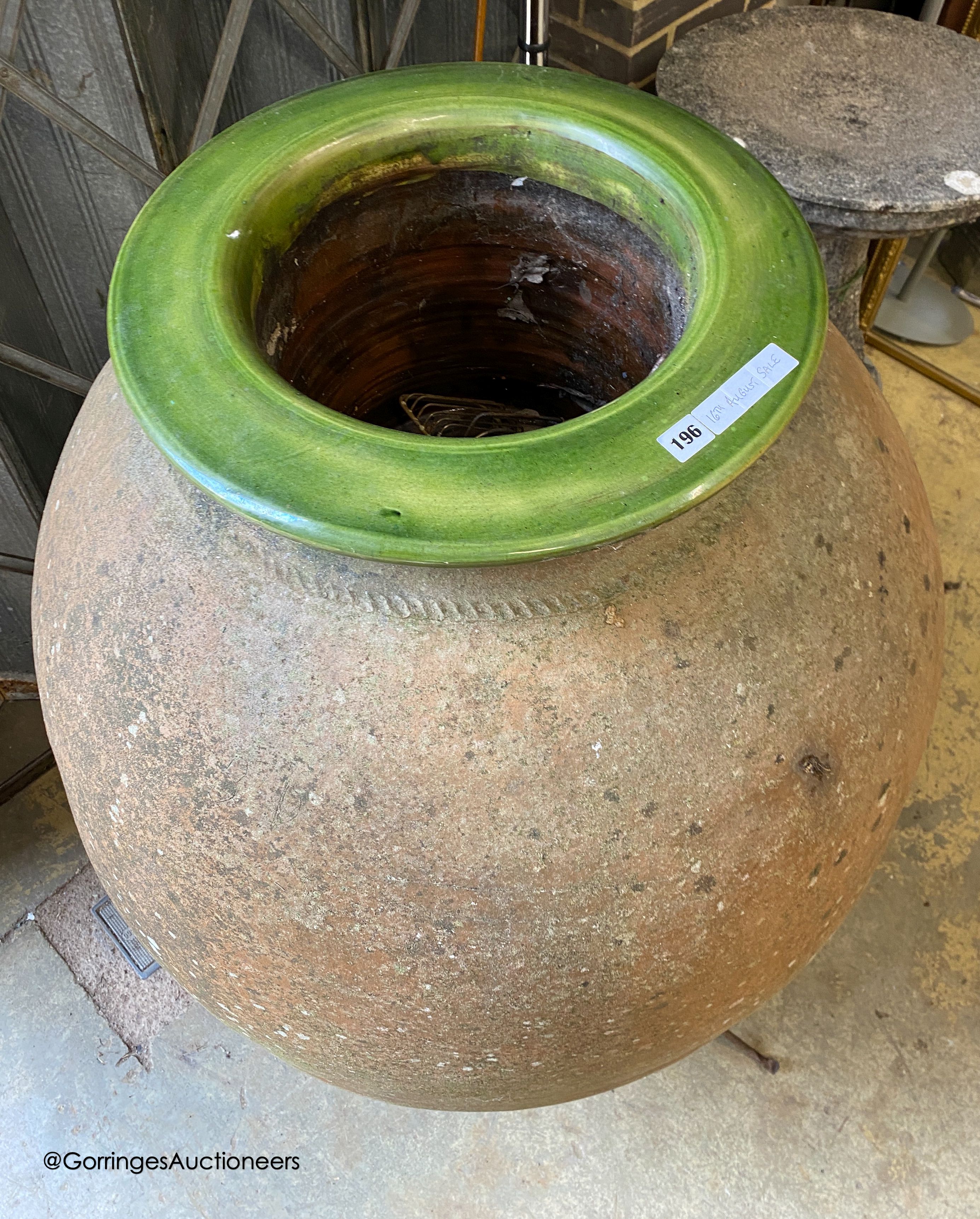 A large antique Italian oil jar, on iron stand with ceramic liner, height 144cm
